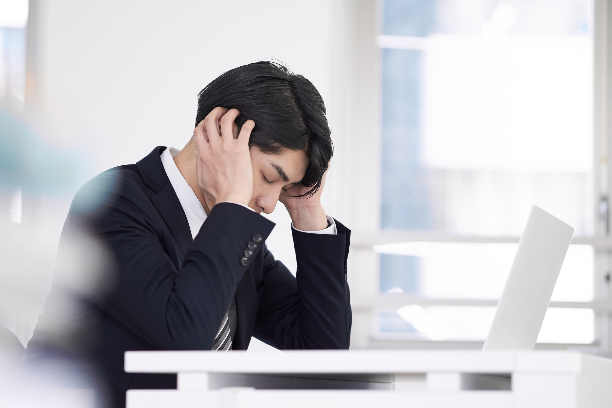 パソコンの前で頭を抱える男性